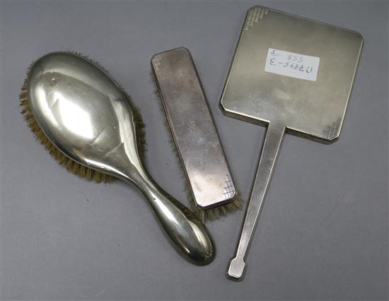 An Art Deco silver mirror and brush and one other silver brush.